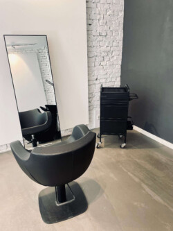 Friseur Berlin Mitte Anja Kieselbach Salon einzelner ledersessel mit großem Spiegel davor, die ganze Szenerie in stylischem Industrial Look